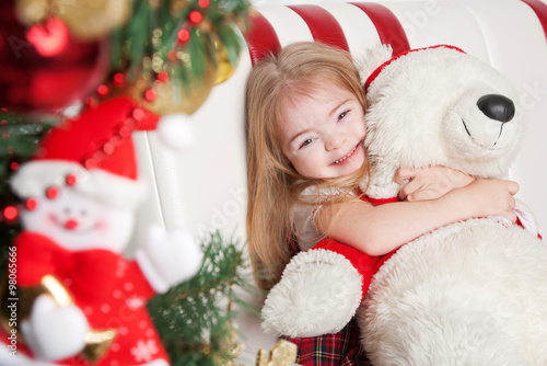 Lovely little girl hugging a teddy bear.