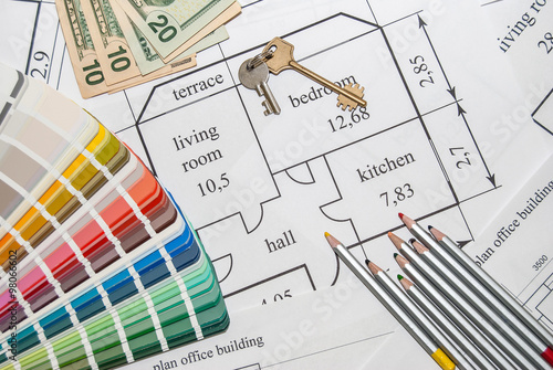 Closeup plan home with a palette of colors, pencils, keys and dollar