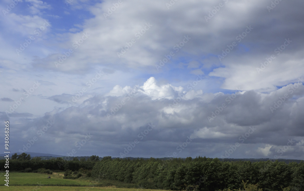 Beautiful blue sky with storm clouds over countryside in Ireland