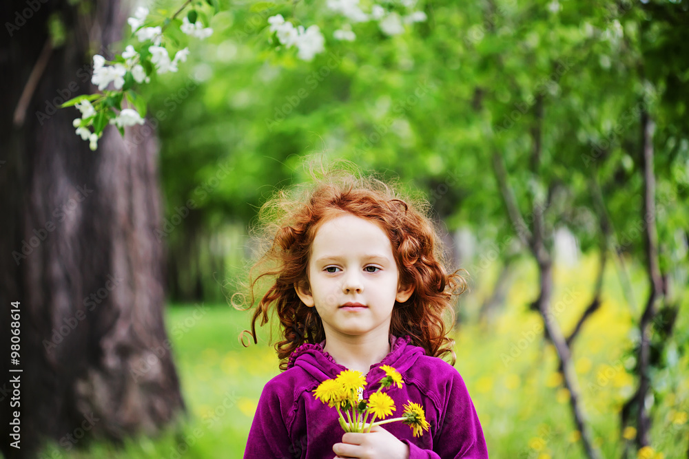 Little girl closed her eyes and breathes yellow dandelions in th Little girl closed her eyes and breathes yellow dandelions in th