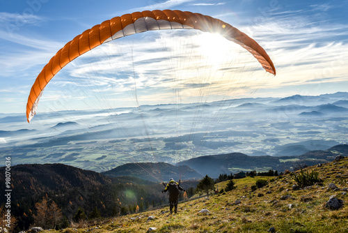 Paraglider is starting off a mountain