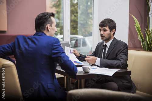 two businessmen communicate happily negotiating in the cafe