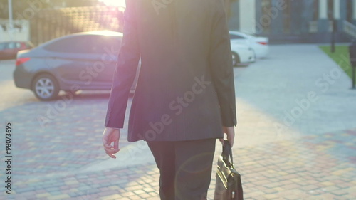 happy businessman in front of an office building with hands open on stairs