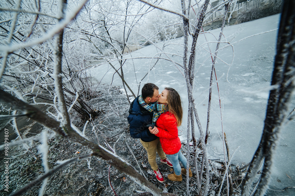 beautiful couple posing near a frozen river beautiful couple posing near a frozen river