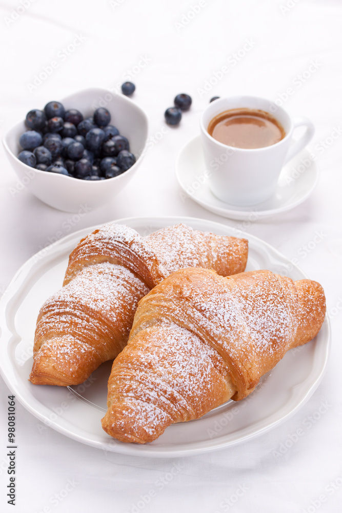 Croissant with coffee and blackberries on a white background. Selective focus. Croissant with coffee and blackberries on a white background. Selective focus.