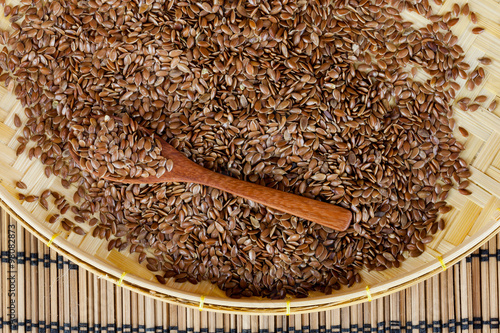 flax seed with spoon placed on flat woven basket