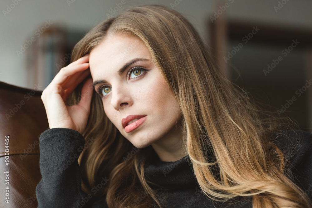 Naklejka premium Attractive thoughtful young woman sitting at home