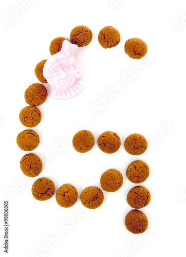 Ginger nuts, pepernoten, in the shape of letter g isolated on wh