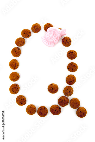 Ginger nuts, pepernoten, in the shape of letter Q isolated on wh