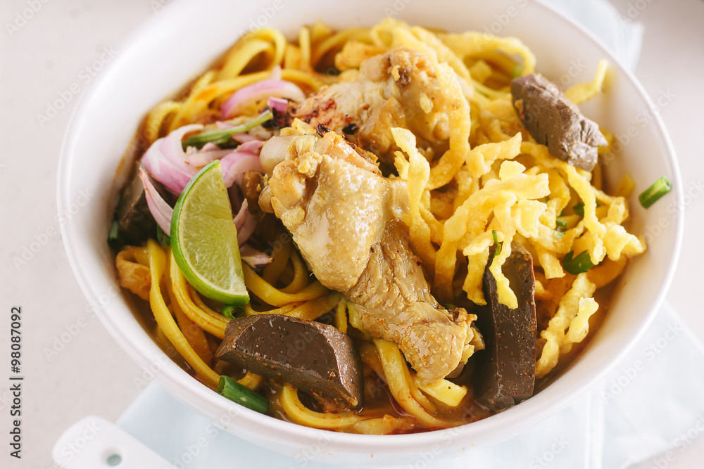 Curried Noodle Soup (Khao soi) with coconut milk, Northern Thai cuisine,shallow Depth of Field,Focus on chicken. Curried Noodle Soup (Khao soi) with coconut milk, Northern Thai cuisine,shallow Depth of Field,Focus on chicken.