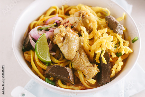 Curried Noodle Soup  Khao soi  with coconut milk  Northern Thai cuisine shallow Depth of Field Focus on chicken.