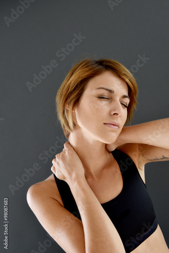 Closeup of fitness girl with neck pain, isolated