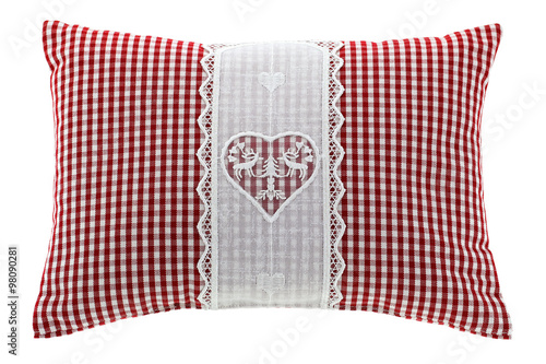 Closeup of a red gingham pillow with flake of Swiss stone pine inside, decorated with hand-made vintage crochet lace, isolated on white background
