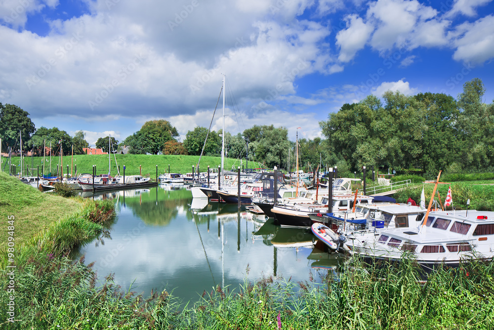 Obraz premium Tranquil harbor with yachts located in a green environment, Woudrichem, The Netherlands