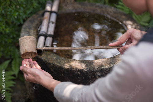 Water-filled basins, called chozubachi, are used by worshipers for washing their hands, mouth and finally the handle of the water ladle to purify themselves before approaching the main Shinto shrine. © ton_kanisorn