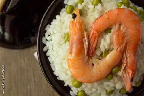 Shrimps and rice with green peas in bowl