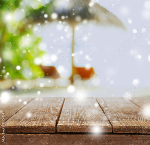 Wooden desk on beach background over snow effect