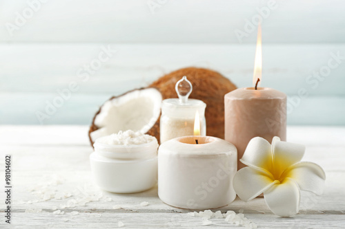 Spa coconut products on light wooden background