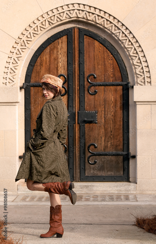 Cute, Fashionable Woman in Front of Old Fashioned Doorway Outdoors