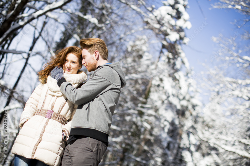 Young couple at winter forest Young couple at winter forest