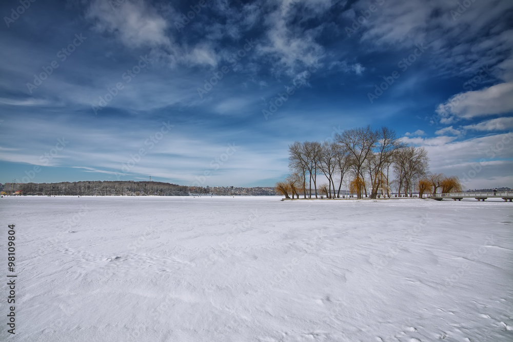 Winter scenery of frozen lake in city park
