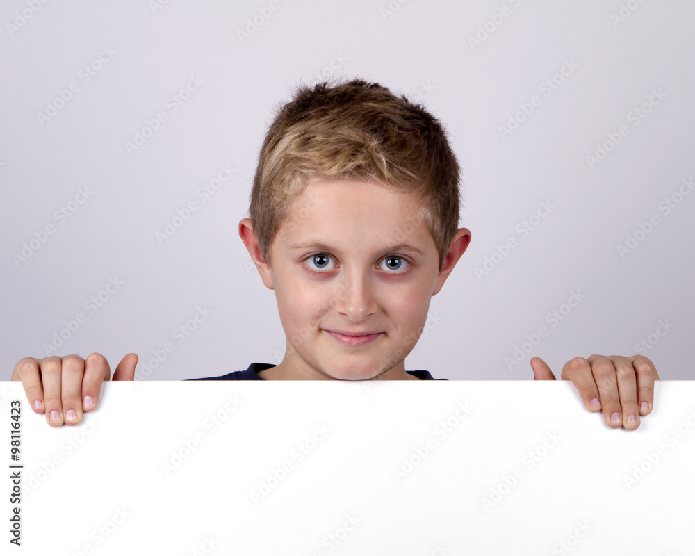 Cute young happy boy holding a blank board against white backgro Cute young happy boy holding a blank board against white backgro
