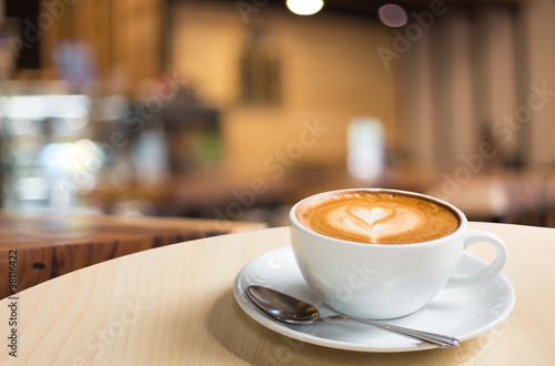 Hot art Latte Coffee in a cup on wooden table and Coffee shop bl