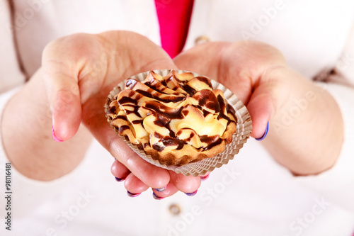 Delicious sweet cupcake in human hands. Gluttony