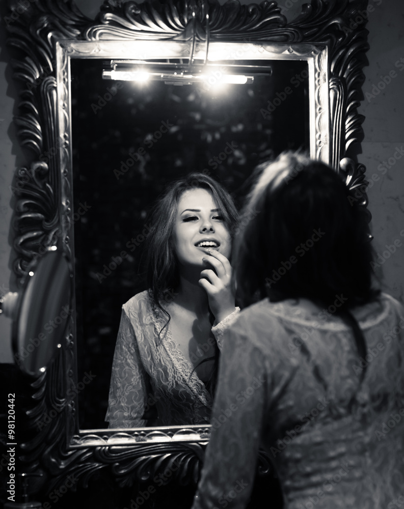 Image of seductive beautiful sexy young woman having fun looking in mirror and happy smiling