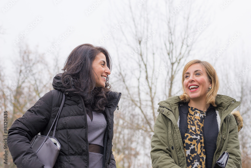 Two young women talking, smiling and having fun outdoors Two young women talking, smiling and having fun outdoors