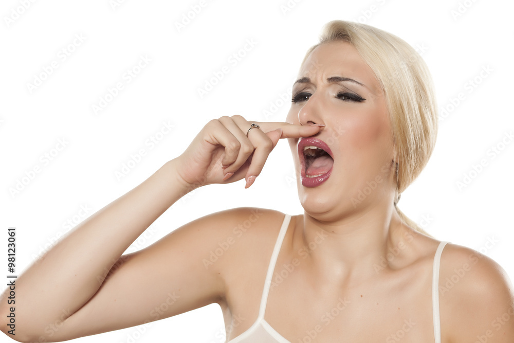 woman holding a finger under the nose because of sneezing woman holding a finger under the nose because of sneezing