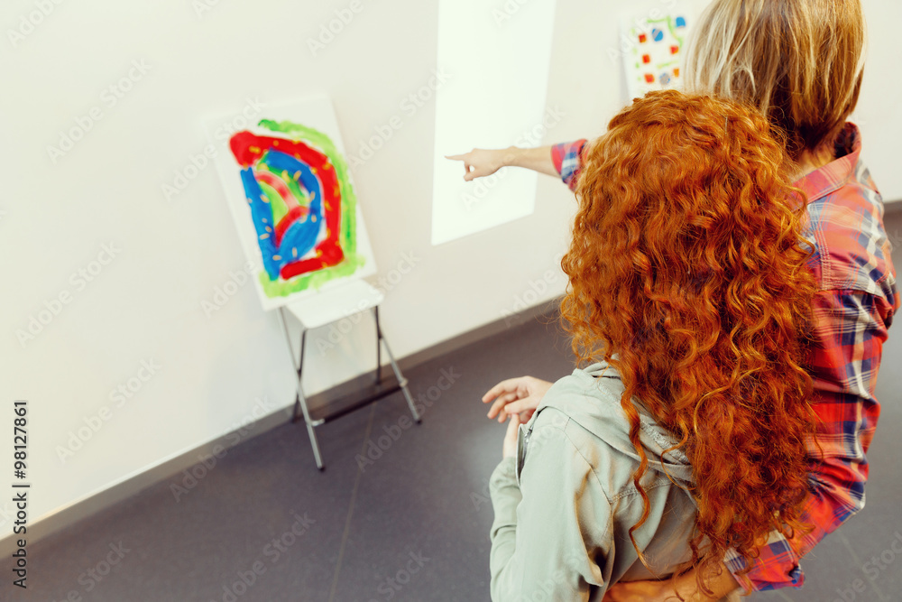Young caucasian couple standing in a gallery and contemplating artwork Young caucasian couple standing in a gallery and contemplating artwork