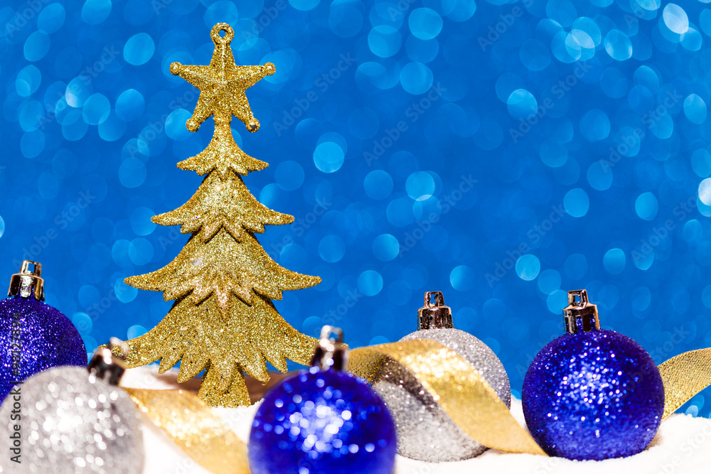 christmas tree and candy in snow on blue glitter background christmas tree and candy in snow on blue glitter background