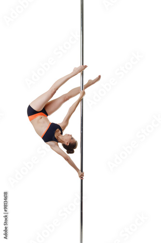 Petite dancer posing upside down on pole