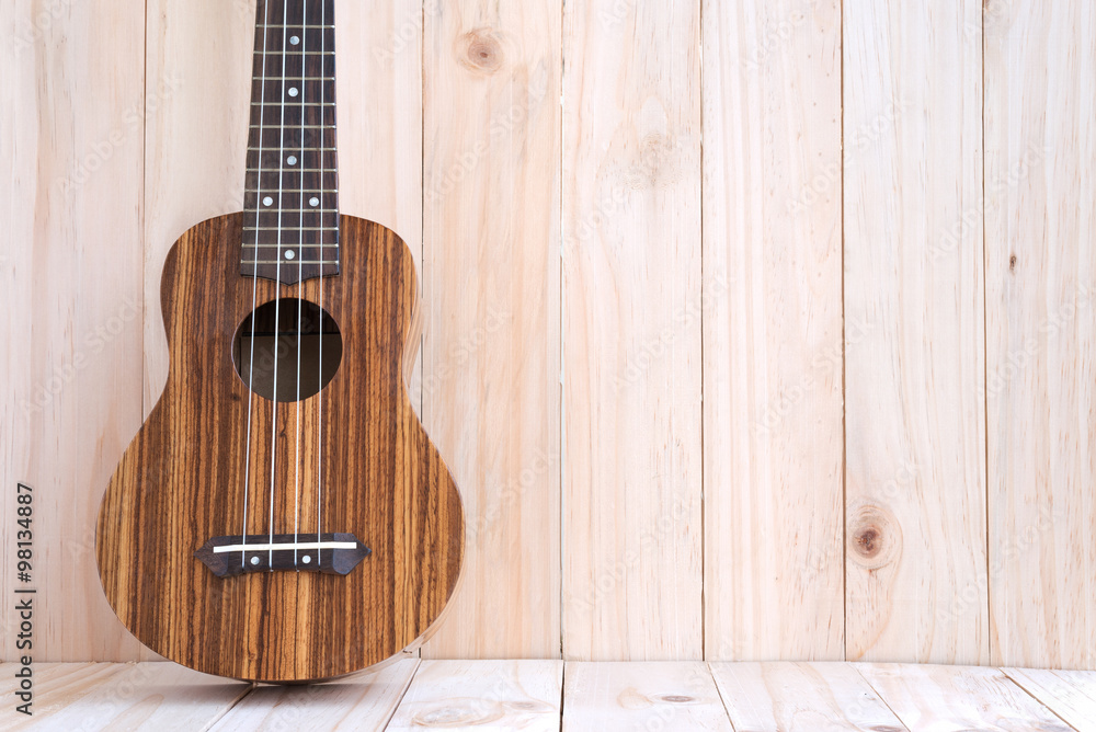 Fototapeta premium The ukulele on wooden background
