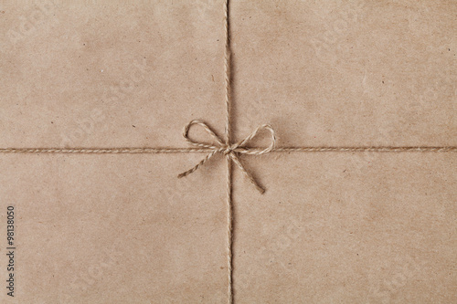 Foto String or twine tied in a bow on kraft paper texture