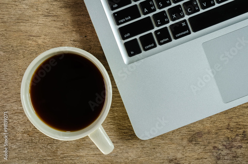  laptop and coffee cup on old wooden table