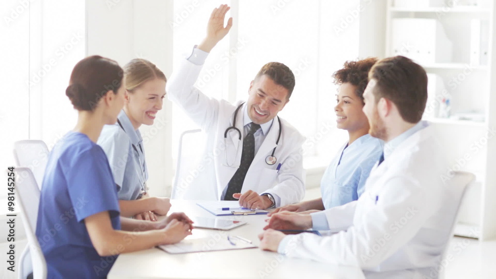 group of happy doctors with hands on top at clinic group of happy doctors with hands on top at clinic