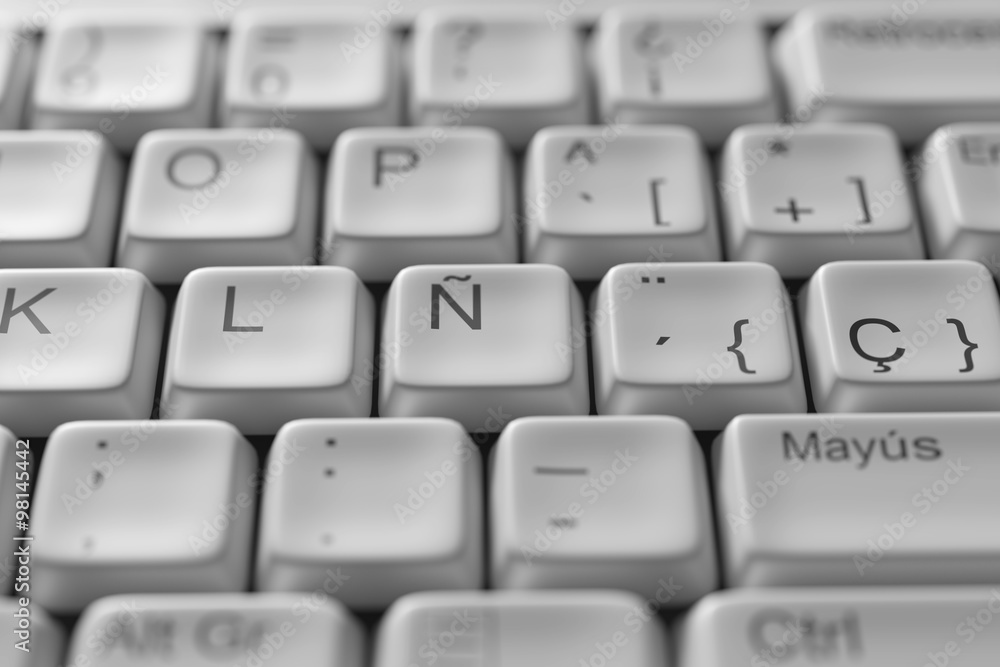 Close-up of white spanish keyboard on wooden table Close-up of white spanish keyboard on wooden table