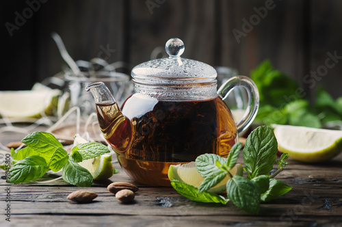 Hot black tea with lemon and mint on the wooden table