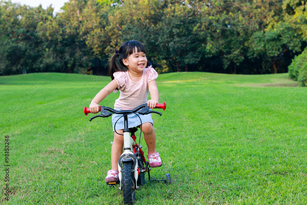 Cute Asian girl enjoy riding bicycle in park Cute Asian girl enjoy riding bicycle in park