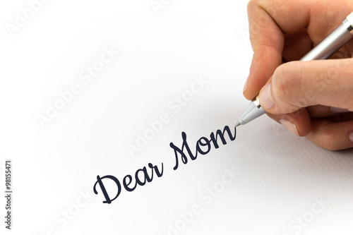 Hand writing "Dear Mom" on white sheet of paper.