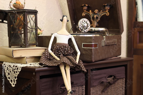 Handmade doll tilda in the coffee with polka dots dress and black hair. Interior dolls photo