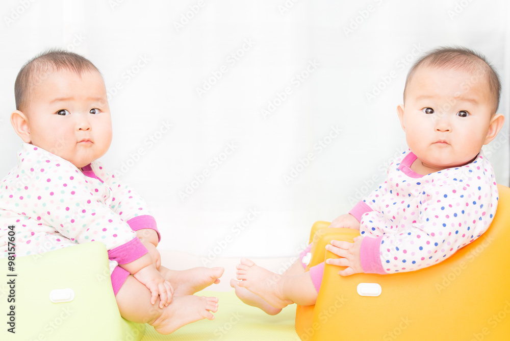 椅子に座っている双子の赤ちゃん 椅子に座っている双子の赤ちゃん