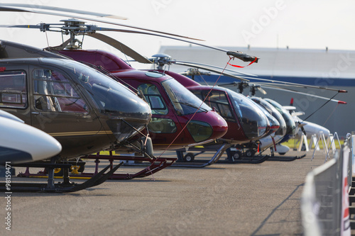 Helicopters lined up on the runway next to each other during the exhibition. No logos.