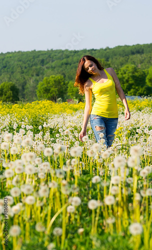 girl on green field with dandelions
