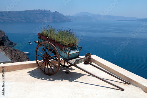 Decorative old cart with flowers on terrace, Santorini, Greece.
