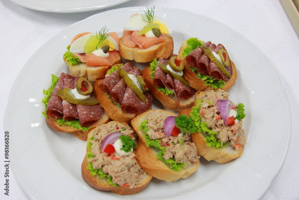 Delicious canapes with tuna, ham, smoke salmon and vegetable on toasted bread Delicious canapes with tuna, ham, smoke salmon and vegetable on toasted bread