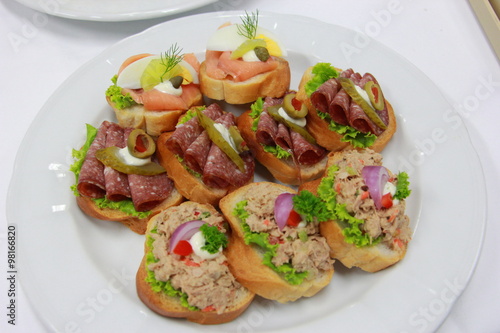 Delicious canapes with tuna, ham, smoke salmon and vegetable on toasted bread