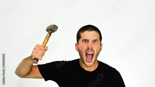 Close-up of aggressive young caucasian man trying to attack you with an hammer - isolated on white background